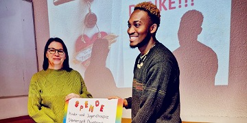Ein Schüler in der Pflegeausbildung übergibt eine Spende an das Kinder- und Jugendhospiz Bamberg