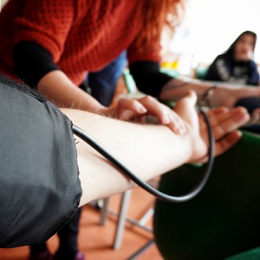 Schüler lernen, wie man den Blutdruck misst.